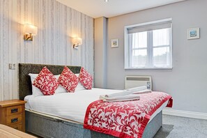 Escritorio, tabla de planchar con plancha y ropa de cama 