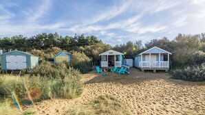 A beachside property with three cabins, each with a porch and seating area. - The Bothy, Ringstead, Norfolk (Ringstead)