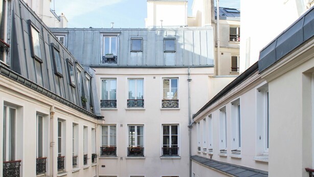 Eine enge Straße mit Häusern, die Balkone und Fenster aufweisen.