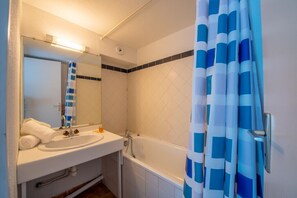 A bathroom with a white sink, mirror, and bathtub. - Nice Apt In Front Of The Marina In Grimaud (Grimaud)