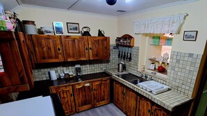 Une cuisine avec des meubles en bois, un pare-feu en carrelage et un réfrigérateur.