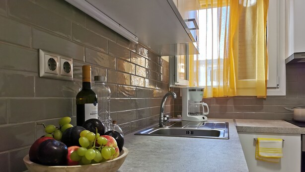 A kitchen with a fruit bowl, a wine bottle, and a coffee maker. - Mon Repo Nest (Corfu)