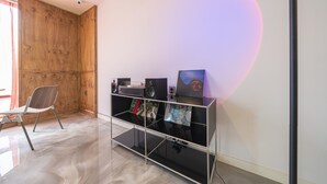 A room with a wooden wardrobe, a glass shelf with speakers and a picture frame, and a chair. - The Shourin in Daejeon (Daejeon)