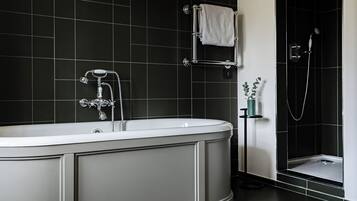 Un baño moderno con una bañera independiente, ducha y perchero para toallas.