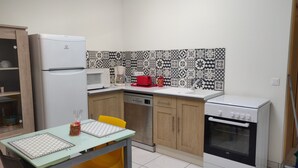 Une cuisine compacte équipée d’un réfrigérateur, d’un four à micro-ondes, d’une machine à café, d’un évier et d’une cuisinière.