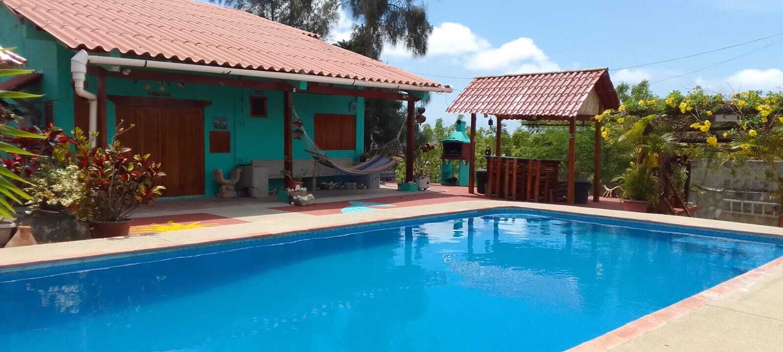 Une piscine avec une maison en arrière-plan.