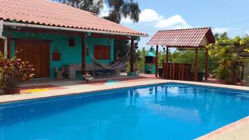 Une piscine avec une maison en arrière-plan.