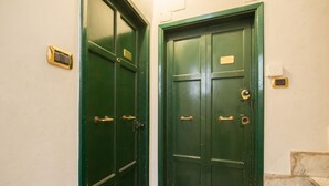 Une porte verte avec une poignée en laiton et une petite plaque en laiton fixée au-dessus.
