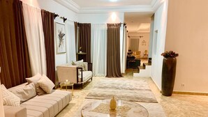 A modern living room with a sofa, a round coffee table, and a large vase. -  Villa Yenne Dakar Diamniadio (Sendou)