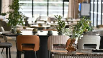 Un restaurante con mesas y sillas, algunas decoradas con plantas.