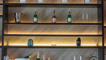 Exhibición de vinos con botellas y copas sobre estantes.