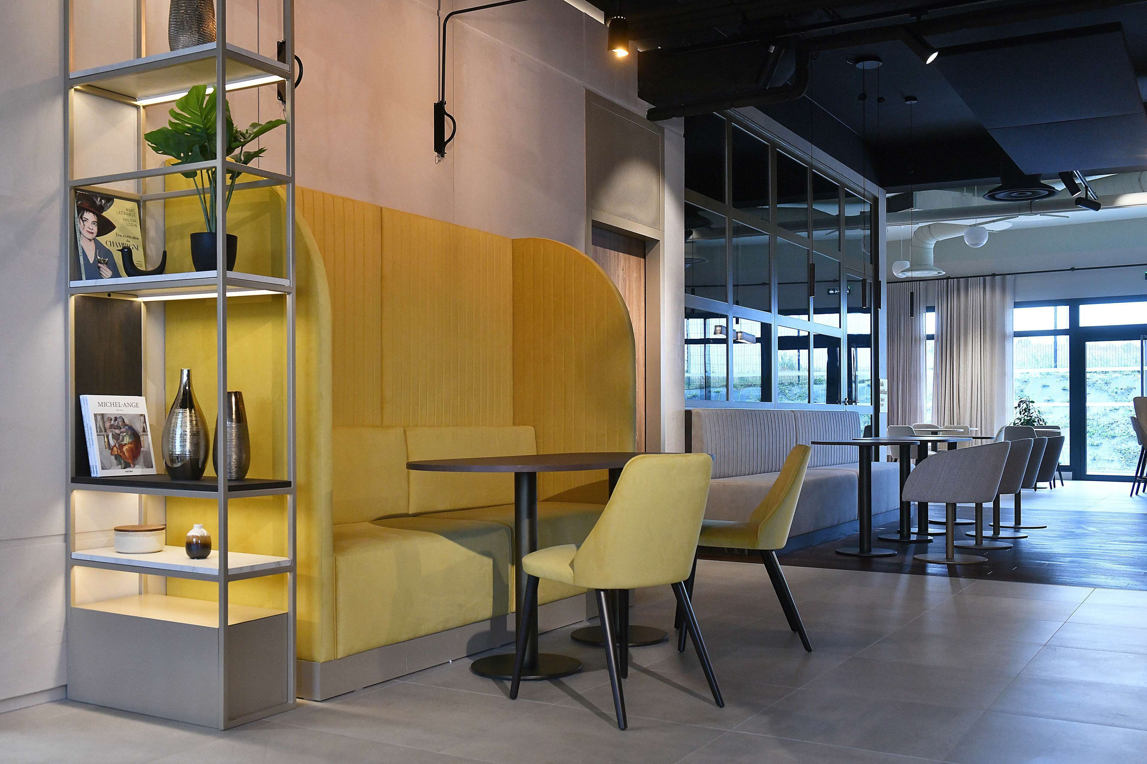 A modern interior with a seating area, a bookshelf, and a table.