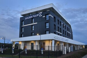 Un hôtel moderne, reconnaissable à son enseigne bien visible indiquant « Golden Tulip Hotel ».