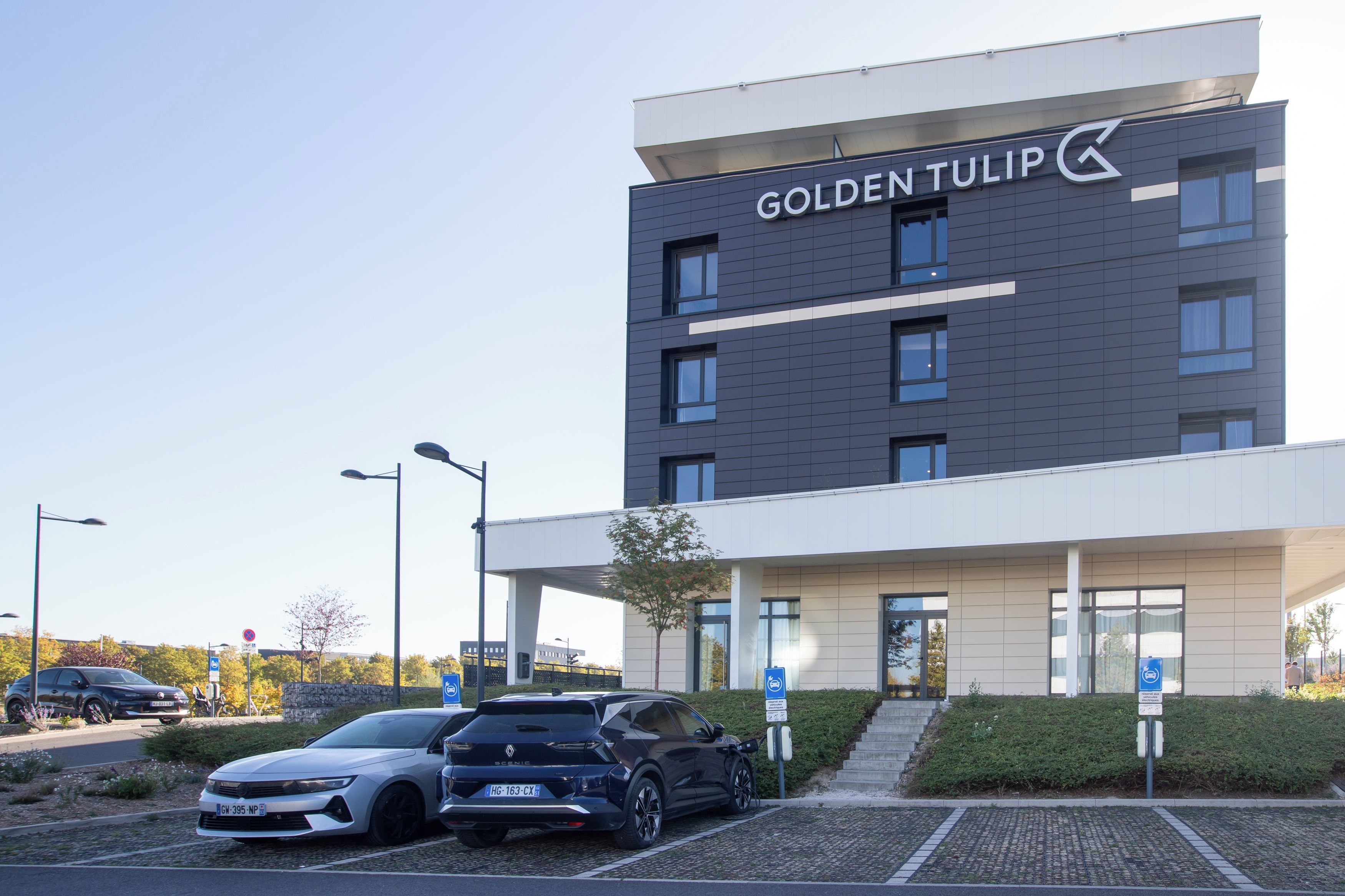 Um edifício moderno de hotel com uma placa que diz 'GOLDENTULIP'.