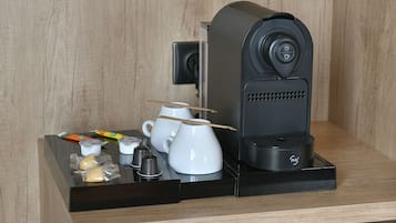 Un ensemble compact pour préparer le café, comprenant une machine à café, des tasses et des condiments.