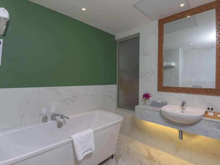 Une salle de bain moderne avec une baignoire, un lavabo et un grand miroir.
