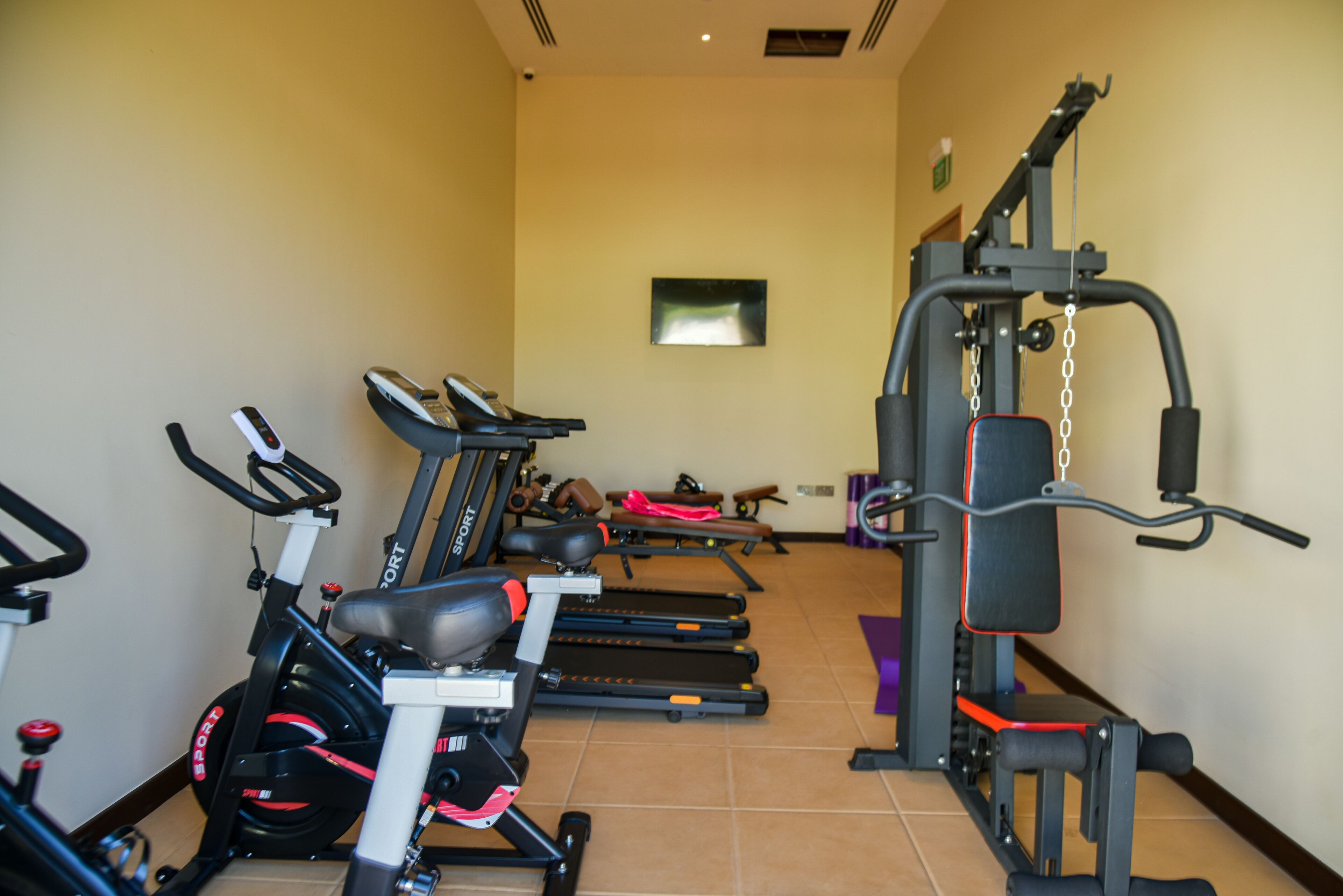 A gym with exercise equipment including treadmills, stationary bikes, and weight machines.