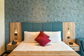 A hotel room with a bed, two bedside tables, a phone, and a red pillow. - Golden Tulip Zanzibar Airport (Zanzibar Town)