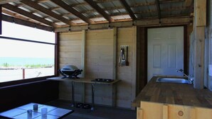 A compact kitchen with a window, a sink, and a small table. - Bunky on the Beach · UNESCO Geopark (Saint Martins Parish)