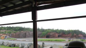 A view through a window with a table, a chair, and a cup. - Bunky on the Beach · UNESCO Geopark (Saint Martins Parish)