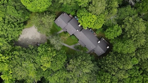 An aerial view of a building surrounded by dense green forest. - Vermont get-away end unit townhouse nestled in the trees  (Hartford)