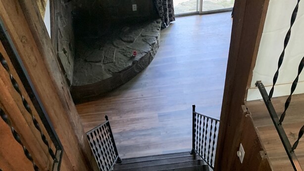 A wooden staircase leading to a stone wall.