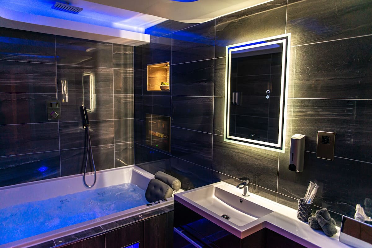 A modern bathroom with a large bathtub, a separate shower area, and a vanity with a sink.