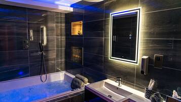 A modern bathroom with a large bathtub, a separate shower area, and a vanity with a sink.