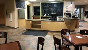 A cafe with a counter, seating area, and a chalkboard menu.