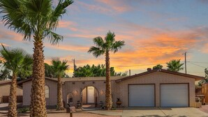 A two-story brick house with a garage, numbered 1709, surrounded by palm trees. - Private Oasis Near Old Mesilla - Home with Pool/Spa (Las Cruces)