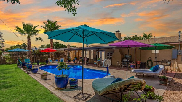 A backyard with a swimming pool, patio furniture, and umbrellas. - Private Oasis Near Old Mesilla - Home with Pool/Spa (Las Cruces)