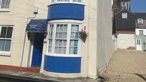 A corner building with a bay window, a blue awning, and a sign reading "Monarch House". - 5 bed, 5 bath, Slps 18, Town Ho. 60 yds Weymth beach & harbour, NEWLY RENOVATED! (Weymouth)