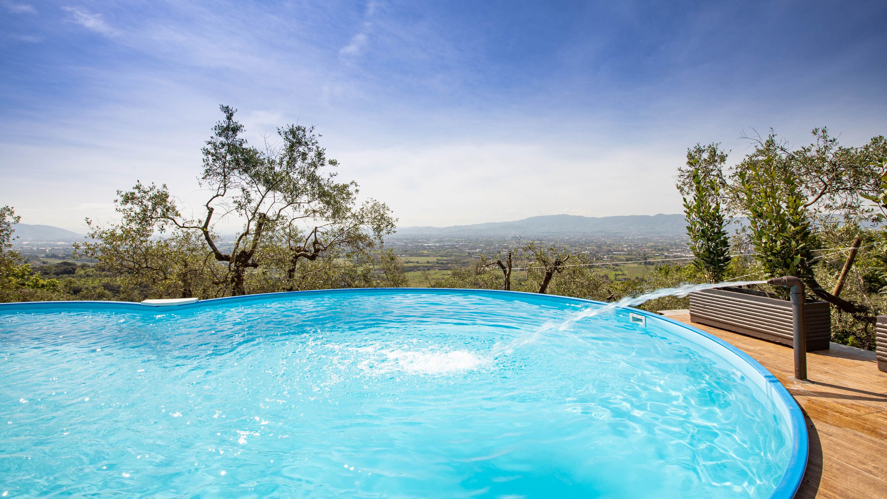 A swimming pool with a view of a cityscape and mountains in the background.
