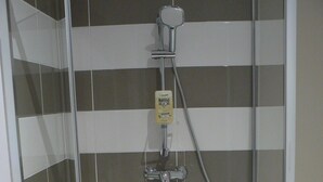 A shower with a handheld showerhead and a handheld shower attachment. - Maison D'hôtes Chambre Family (La Chailleuse)