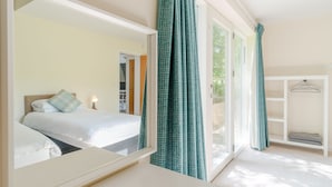 A bedroom with a bed, a nightstand, a mirror, and a sliding glass door leading to a balcony. - Ledge View  - sleeps 6 guests  in 3 bedrooms (Weston Subedge)
