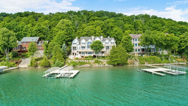 A lakeside property with multiple buildings, docks, and a clear view of the surrounding forest.