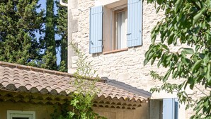 Un edificio in pietra con tetto in tegole e un piccolo giardino.