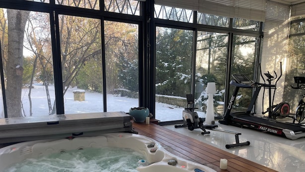 Un jacuzzi, equipo de ejercicios y vistas a un paisaje nevado a través de amplios ventanales.