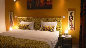 Una habitación de hotel con una cama grande, dos mesitas de noche y un cuadro en la pared.