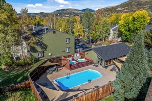 A residential property with a swimming pool, outdoor hot tub, and a fenced backyard.
