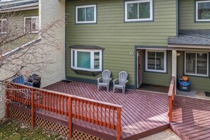 A green house with a wooden deck, two white chairs, and a small window. - Close to the Slopes! On Free Bus Route! Summer Pool! (Steamboat Springs)