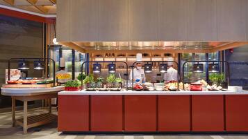 Un buffet proposant une grande variété de plats et un chef qui prépare les aliments.