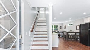 Una escalera que conduce a un espacio de estar con cocina y comedor.