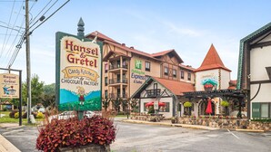 Un edificio con letreros que indican Hansel & Gretel Candy Kitchen & Chocolate Factory, Holiday Inn Express & Suites y King's Court.