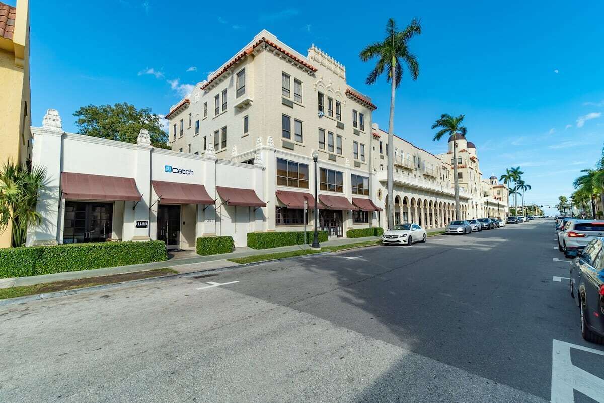 Ein Hotel mit klassischer Architektur, das einen zentralen Innenhof, zahlreiche Balkone und einen markanten Eingangsbereich mit Markisen bietet.