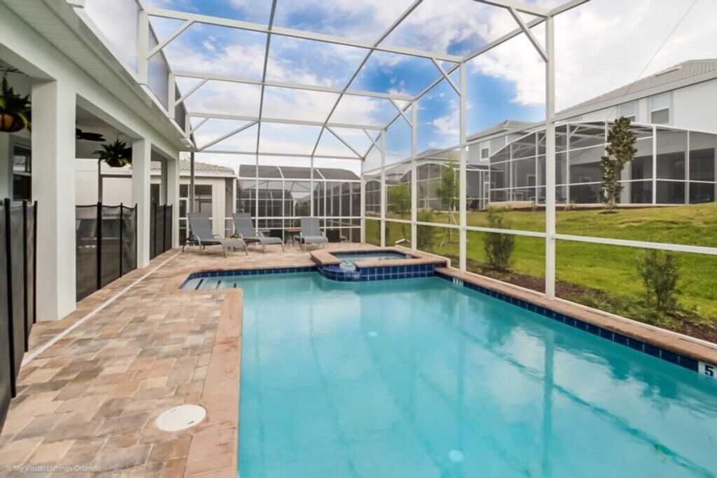 Ein Pool mit Glasabdeckung, eine Whirlwanne und eine Terrassenanlage mit Sitzgelegenheiten.