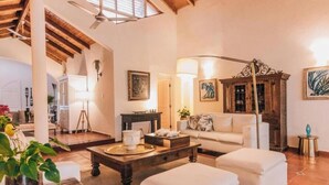 A spacious living area with a high ceiling, a fireplace, and a dining table. - Lux Villa, Casa de Campo (La Romana)