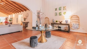 A spacious living area with a glass-top coffee table, a white sofa, and a wooden ceiling. - Lux Villa, Casa de Campo (La Romana)