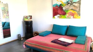 Una camera da letto con un letto grande, una cassettiera, uno specchio e un quadro astratto dai colori vivaci appeso al muro.