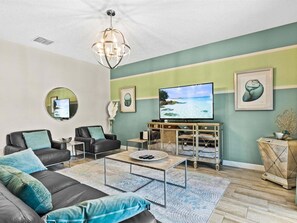 A living room with a TV, two sofas, a coffee table, and a decorative cabinet.